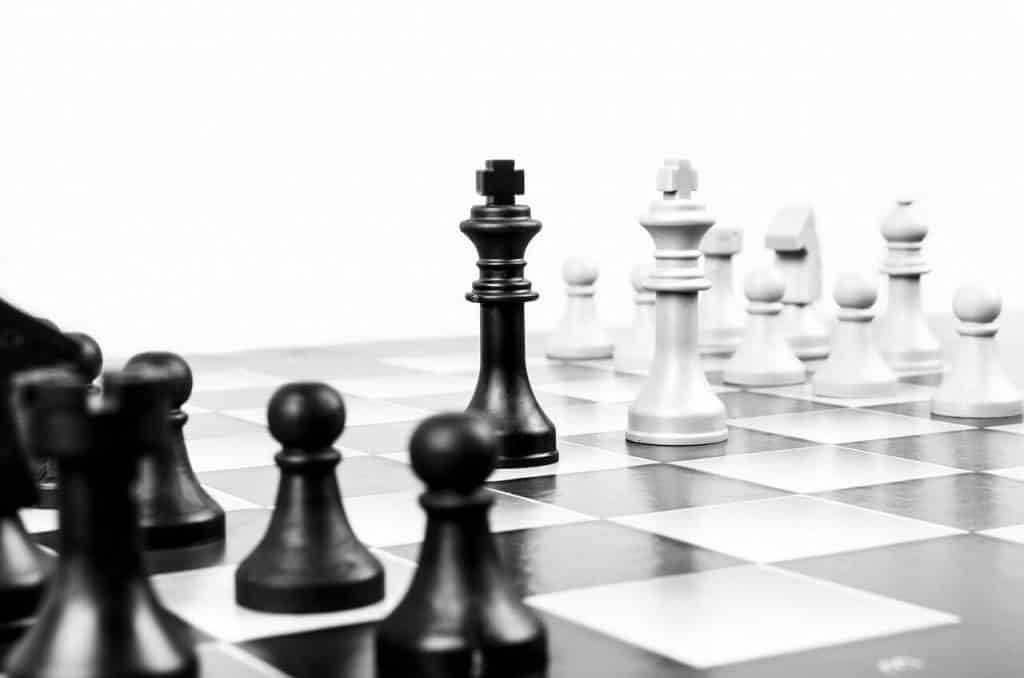 black and white chessboard with the pieces in place except the queens are in the middle