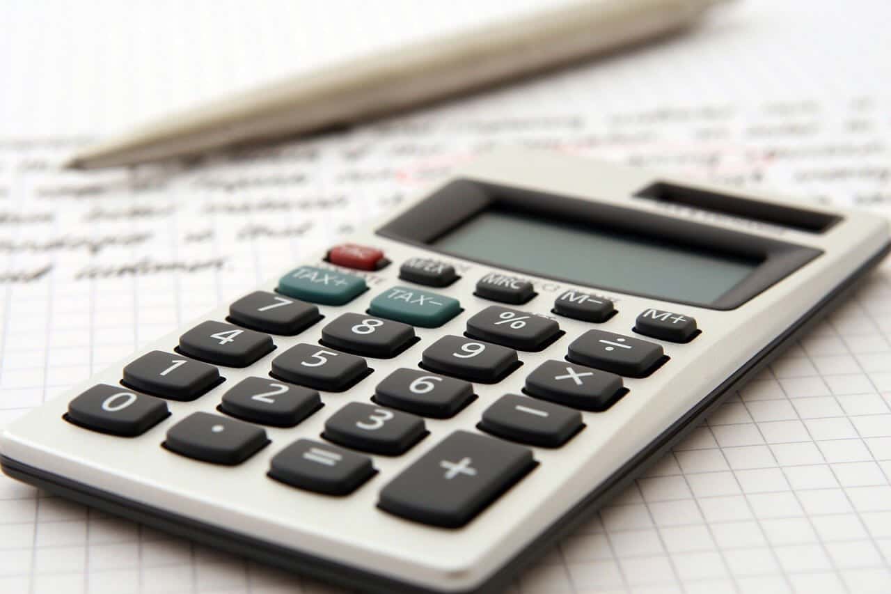 calculator sitting on grid paper with a pencil laying beside the calculator