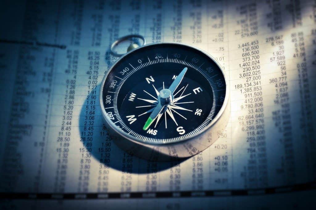 compass sitting on financial papers
