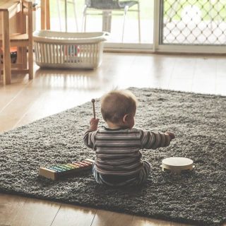 baby playing instruments on the floor