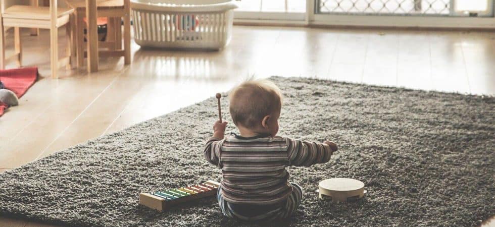 baby playing instruments on the floor