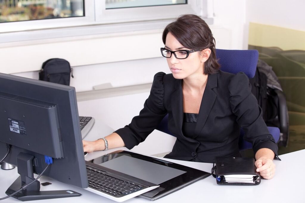 dark haired woman doing bookkeeping at her computer
