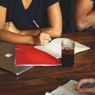 woman in black shirt taking notes